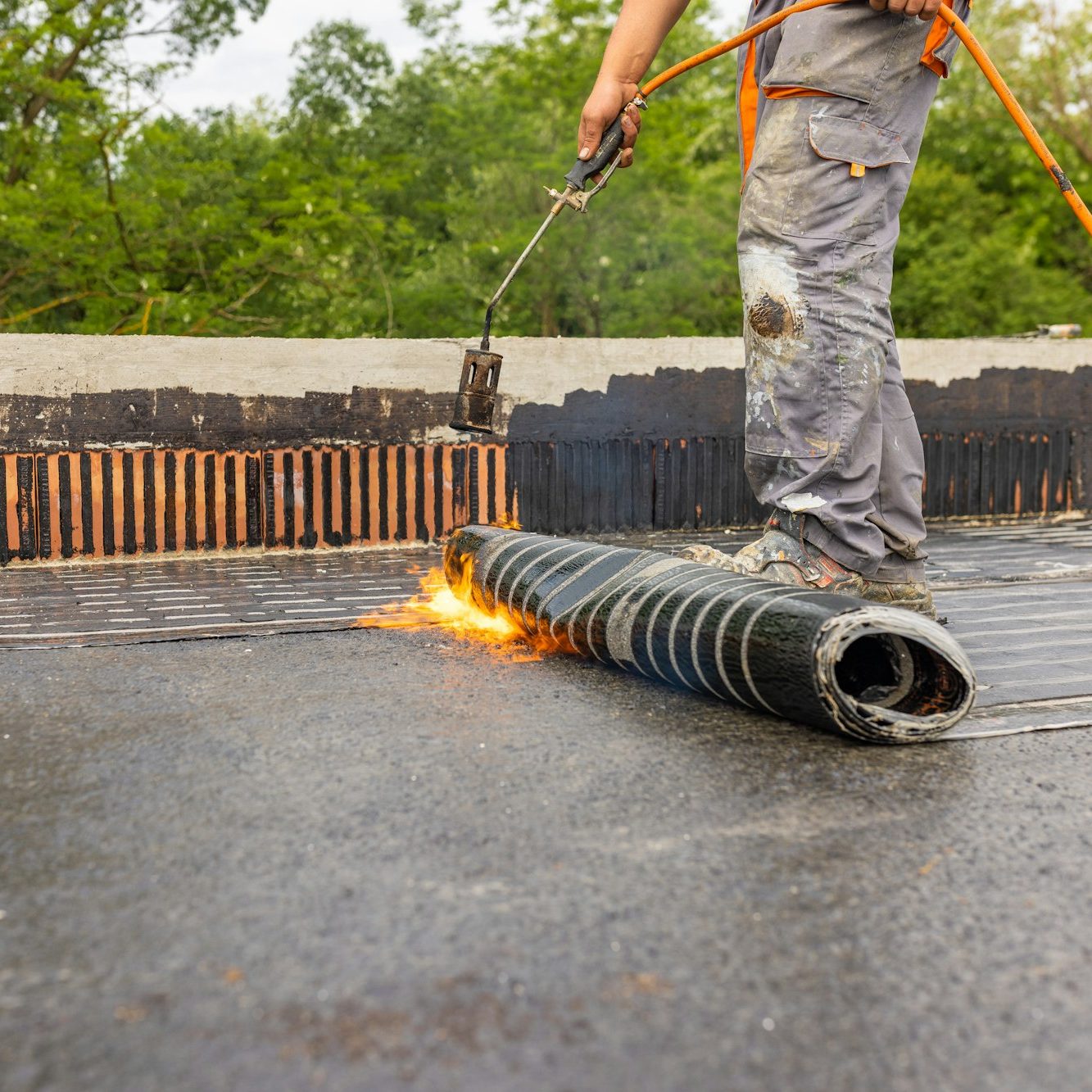 Bituminous membrane waterproofing system details and installation on flat rooftop.